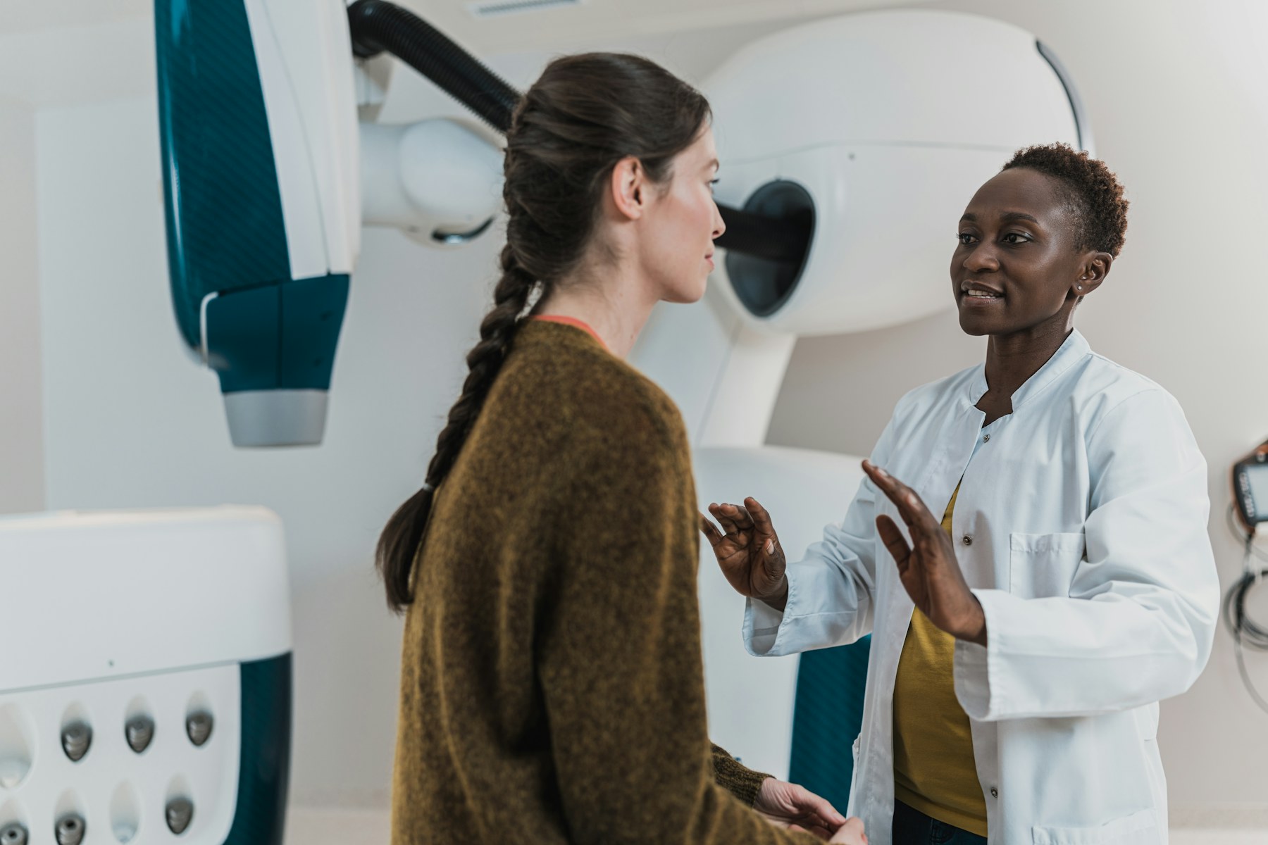 Physician speaking with a patient in a clinical imaging room